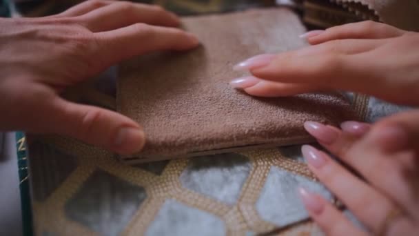 Closeup of female and male hands choosing fabric cloth for curtain at catalog — Stock Video