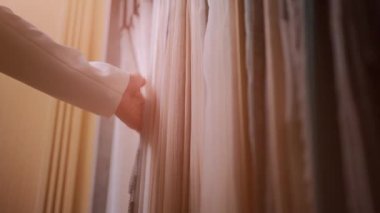 Mağazada ya da mağazada perde için kumaş seçen kadın elinin yakın çekimi