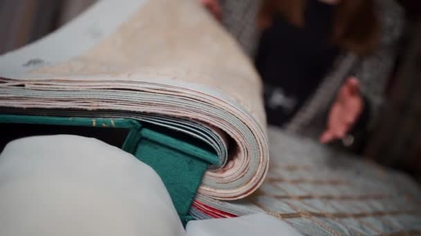 Närbild av designer kvinnliga visa tyg prov gardin katalog i textilbutik — Stockvideo