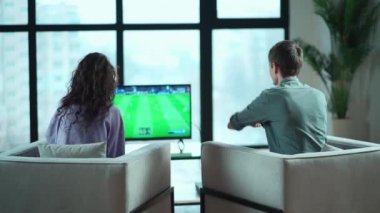 Mutlu çift evde Playstation 'da oyun oynuyorlar.