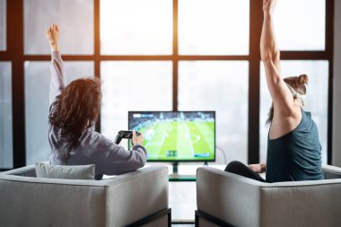 Mutlu çift evde Playstation 'da oyun oynuyorlar.