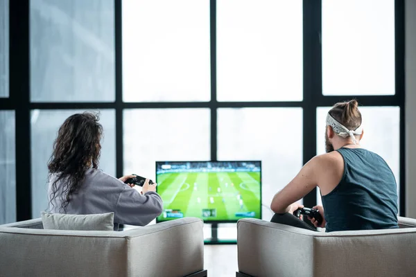 Glückliches Paar spielt Videospiel mit Controller auf Playstation zu Hause — Stockfoto