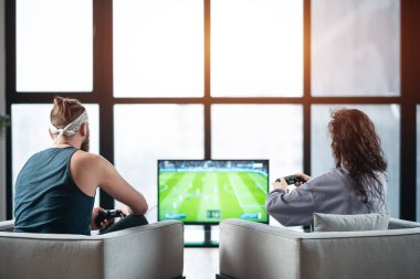 Mutlu çift evde Playstation 'da oyun oynuyorlar.