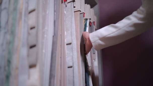 Close-up van vrouwelijke hand kiezen stof doek voor gordijn in showroom of winkel — Stockvideo