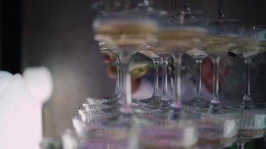 Şenlikli şampanya piramidine barmen doldurup buzlu alkol servis ediyor.