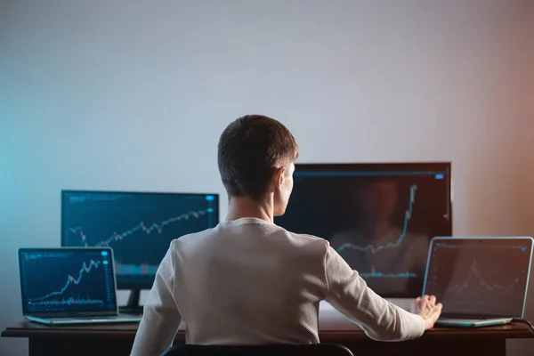 Menkul kıymetler borsası grafiği veya grafiği ile monitöre bakan erkek tüccarın arka planı