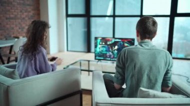 Çift evde oyun istasyonu konsolunda denetleyici ile video oyunu oynuyor