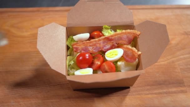 Close-up de cozinheiro chef mão em luvas médicas colocar salada fresca em recipiente de comida — Vídeo de Stock
