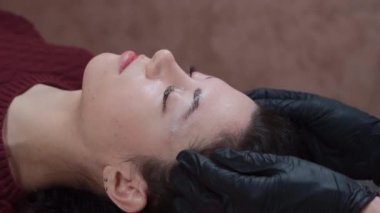 Kozmetikçide gençleşen kafa ya da yüz masajı prosedürü üzerine çalışan güzel bir kadın.