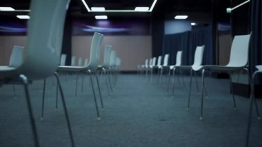 Koltuklar arasında önleyici mesafesi olan boş modern konferans salonu.