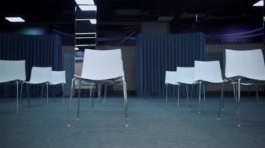 Koltuklar arasında önleyici mesafesi olan boş modern konferans salonu.