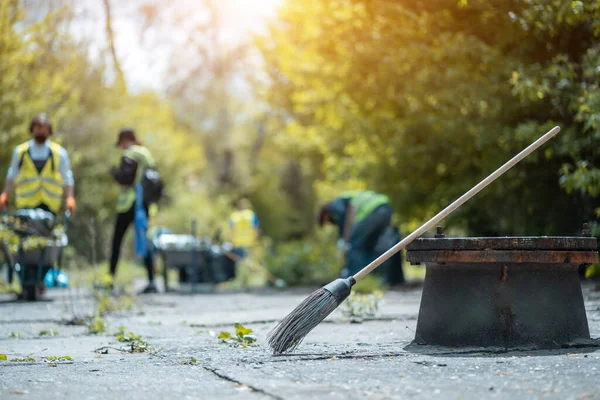 Sokakta yatan süpürgeler, toprak, atık ve yapraklardan parkı temizleyen gönüllüler. — Stok fotoğraf