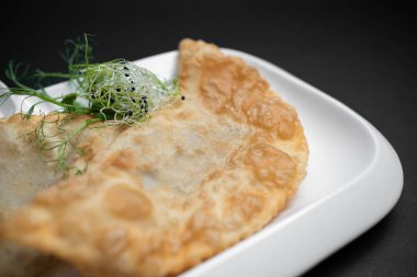 cheburek ya da kızarmış hamur turtası et hissi ve siyah arkaplanda sos