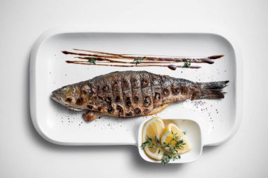 Beyaz arka planda limonlu ızgara doldurulmuş balığın üst görüntüsü