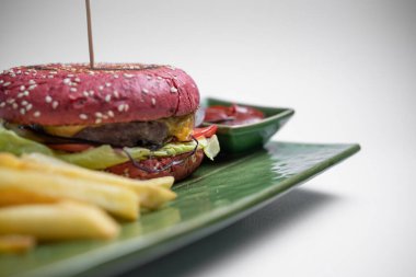 Yakın plan taze kırmızı burger esprisi patates kızartması ve beyaz arka plan sosu.