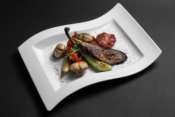 Primo piano di verdure grigliate e champignon su piatto bianco su fondo nero — Foto Stock