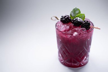 Şarap kadehinde böğürtlenli özel alkollü yaban mersini kokteyli.