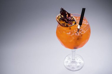 Turuncu aperol spreyli lychee kokteylini beyaz arka planda cama yakın tut.