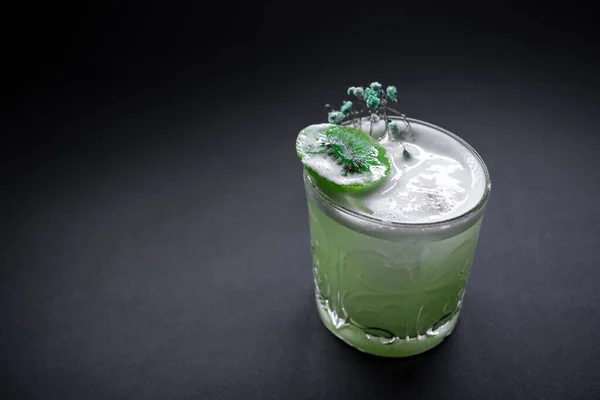 Свежий зеленый киви удар алкоголь коктейль напиток в винном бокале на черном фоне — стоковое фото