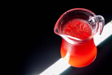 Kırmızı böğürtlenli limonata ya da buzlu ve siyah arka planda buzlu çilekli içecek.