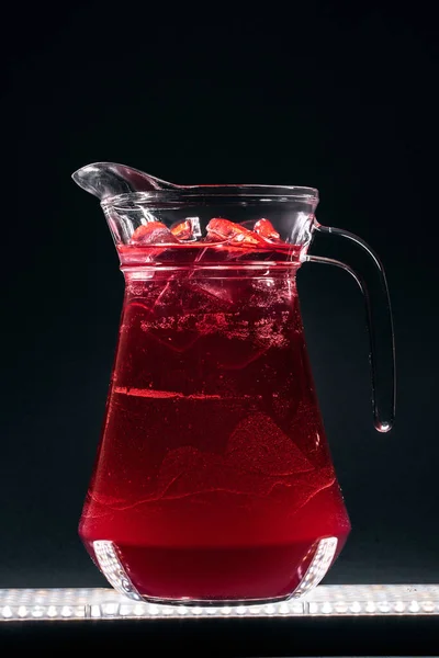 Cruche en verre avec boisson gazeuse à la limonade cerise rafraîchissante ou glace sur fond noir — Photo