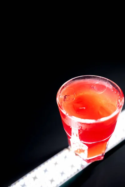 Limonada de bayas rojas o bebida de fresa con hielo en vidrio sobre fondo negro — Foto de Stock