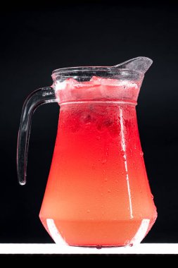 Kırmızı böğürtlenli limonata ya da buzlu ve siyah arka planda buzlu çilekli içecek.