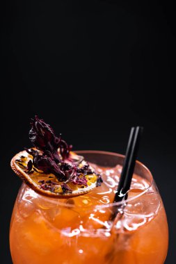 Siyah arka planda, cam içinde portakallı aperol spreyi likörü kokteylini kapat.