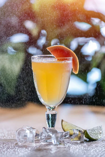 Verfrissende limonadedrank met grapefruit en ijs in glas onder water sproeien — Stockfoto