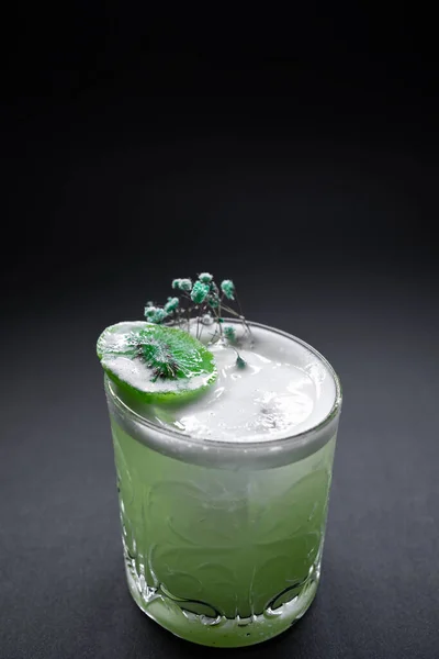 Свежий зеленый киви удар алкоголь коктейль напиток в винном бокале на черном фоне — стоковое фото