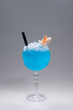 Gri arka planda camla süslenmiş lüks mavi alkol kokteyli.