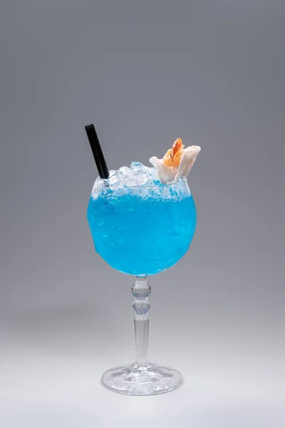 Luxusní modrý alkohol koktejl zdobený krevetami ve skle na šedém pozadí — Stock fotografie