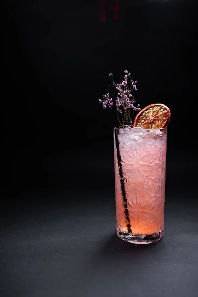 Bebida de limonada de lujo o cóctel rosa con hielo en vidrio sobre fondo negro — Foto de Stock