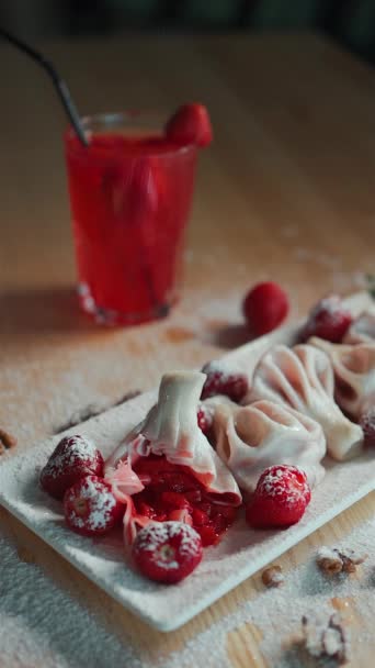 Sweet khinkali with berry filling or strawberry falling on table and red drink — Stock Video