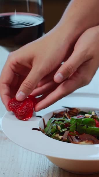 Salad with arugula, meat ham and berry or hands decorating dish with strawberry — Stock Video