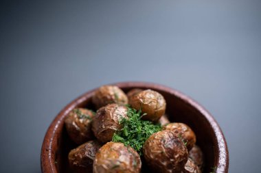 Kil kasede siyah arka planda otlu kızarmış patatesleri yakın.