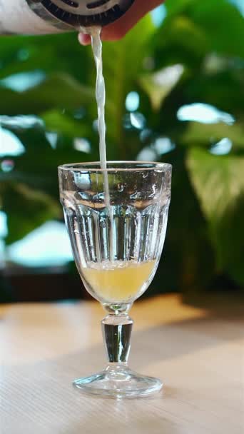 Ruční nalévání žlutého tropického koktejlu ve skleněné číši nebo příprava studeného nápoje — Stock video