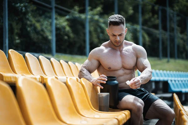 Muscular athlete male preparing protein whey drink after exercising outdoor — Stock Photo, Image