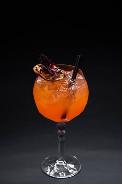 Siyah arka planda, cam içinde portakallı aperol spreyi likörü kokteylini kapat.