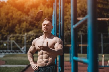 Kaslı sporcu dışarıda protein tozuyla siyah kabı kusar.