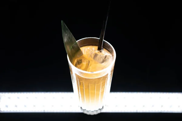 Refreshing lemonade drink or cocktail with ice cube in glass on black background — Stock Photo, Image