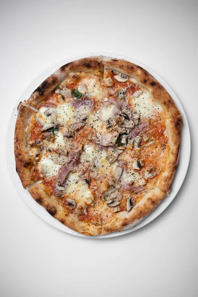 Beyaz arka planda jambonlu, mantarlı ve peynirli İtalyan pizzası.