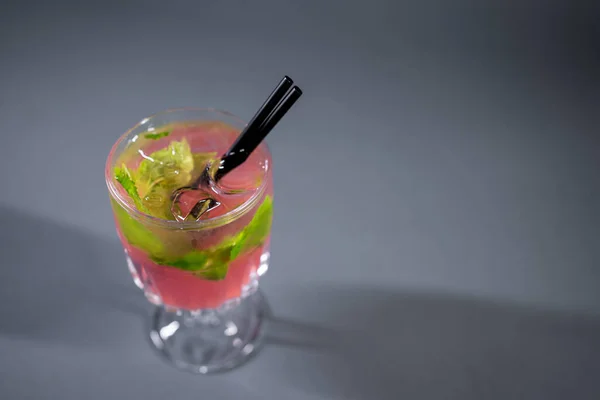 Erfrischende rosa Limonade mit Minz- oder Rosencocktail im Glas auf grauem Hintergrund — Stockfoto