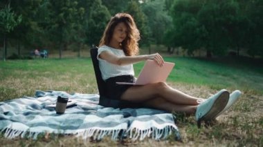 Çekici kız serbest yazar dışarıda, parkta dizüstü bilgisayarla çalışmaya başladı.