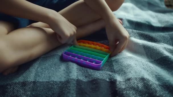 Nahaufnahme von Kinderhänden, die mit Popit spielen oder Antistress-sensorisches Spielzeug schieben — Stockvideo