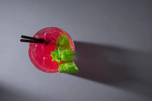 Detailní záběr červeného jahodového koktejlového nápoje s mátou ve skle na šedém pozadí — Stock fotografie