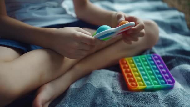 Nahaufnahme von Kinderhänden, die mit einfachen Grübchen spielen oder Antistress-Spielzeug schieben — Stockvideo