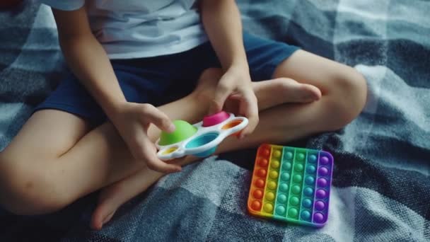 Крупним планом дитячі руки грають з простим тьмяним або штовхаючим антистресовою іграшкою — стокове відео