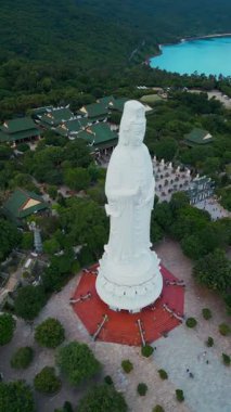 Linh Ung tapınağındaki dindar Buda Anıtı ve Budizm tapınağı, Asya dini ve ruhaniyeti, Son Tra yarımadası, Da Nang, Vietnam 4k hava aracı görüşü. Yüksek kaliteli görüntüler, dikey video