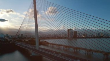 Da Nang 'daki Han Nehri üzerinde modern kablolu köprü, Vietnam' ın su yolu boyunca şehrin ufuk çizgisini bağlayan modern kentsel açıklık, hava aracı manzarası. Yüksek kalite 4k görüntü
